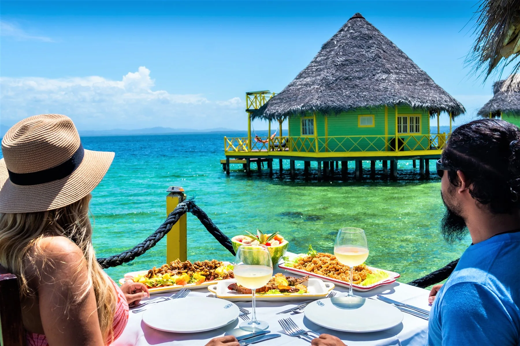 Guests dining on a deck overlooking the overwater bungalows at the boutique hotel in Bocas del Toro, Panama