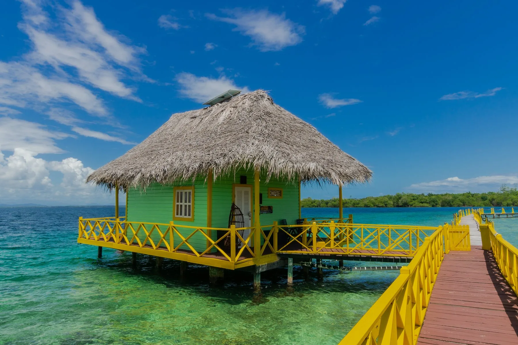 An overwater bungalow with a thatched roof at the boutique hotel in Bocas del Toro, Panama